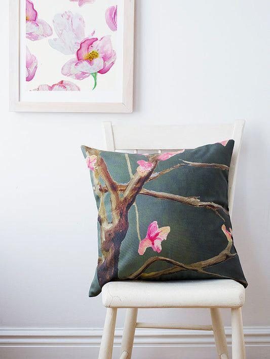 Decorative pillow with floral design on a chair, framed floral art in the background.